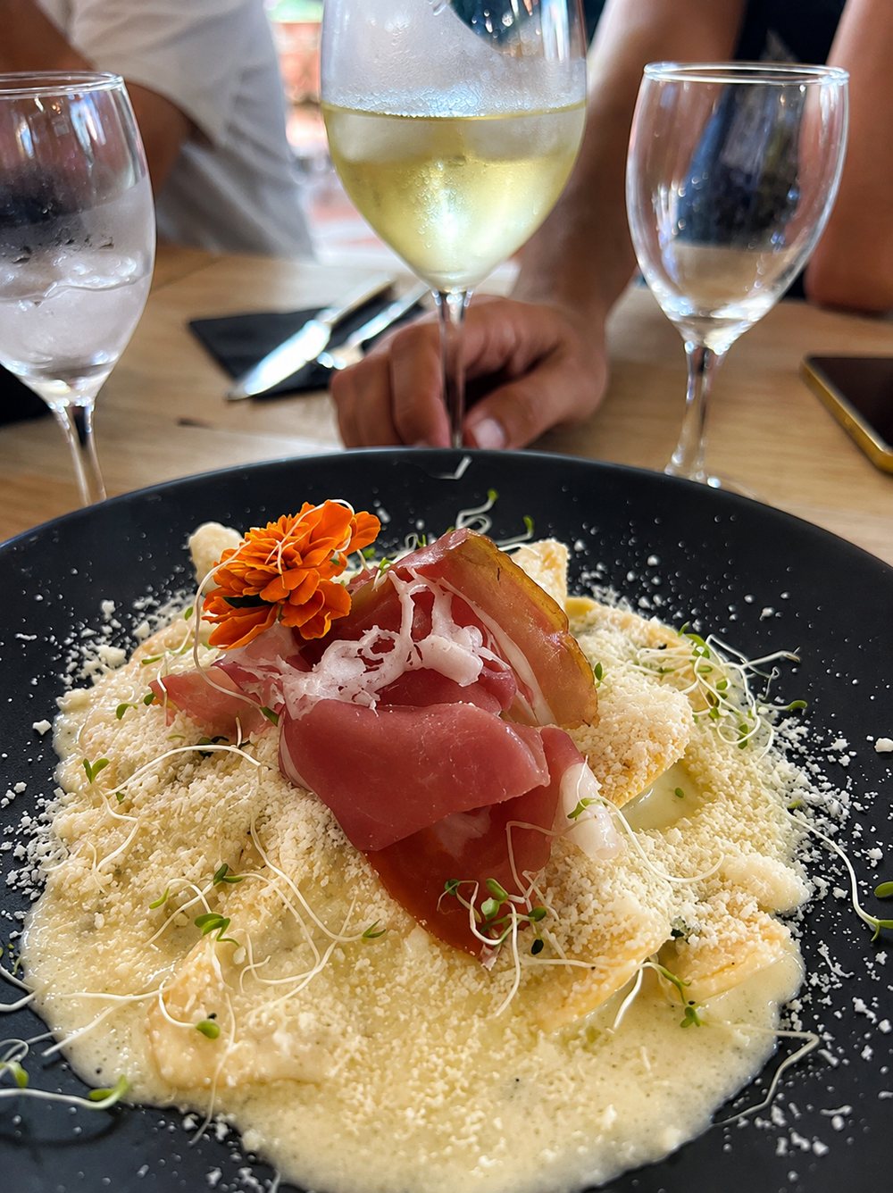 Raviole crémeuse au parmesan et jambon italien, dressée en salle chez Casa Italia